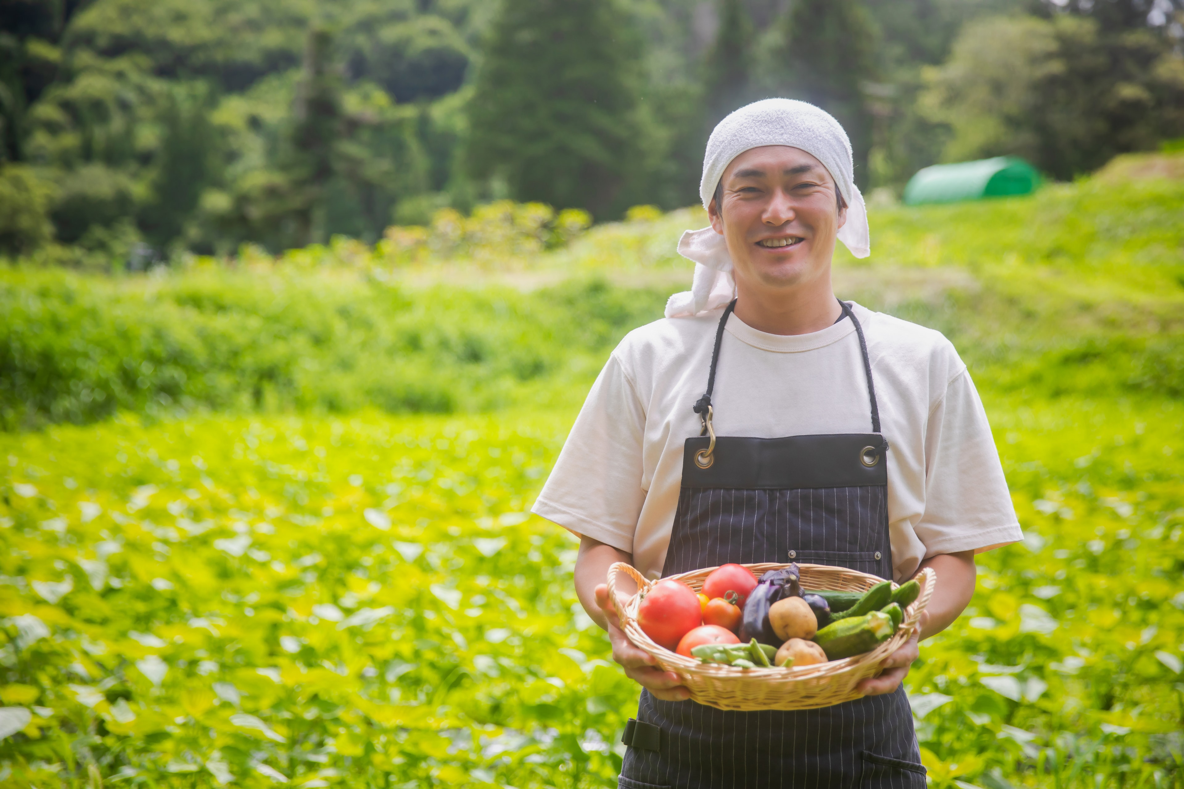野菜を持つ笑顔の農家